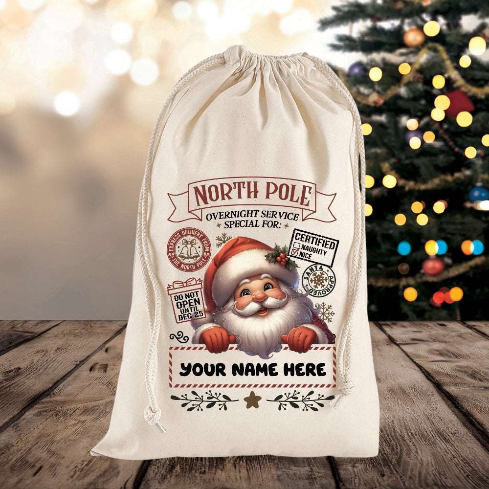 Personalized Santa sack with festive design on a wooden surface with a Christmas tree in the background.