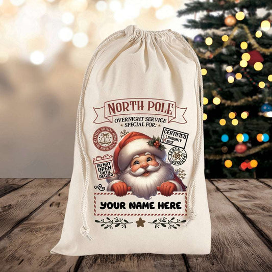Personalized Santa sack with festive design on a wooden surface with a Christmas tree in the background.