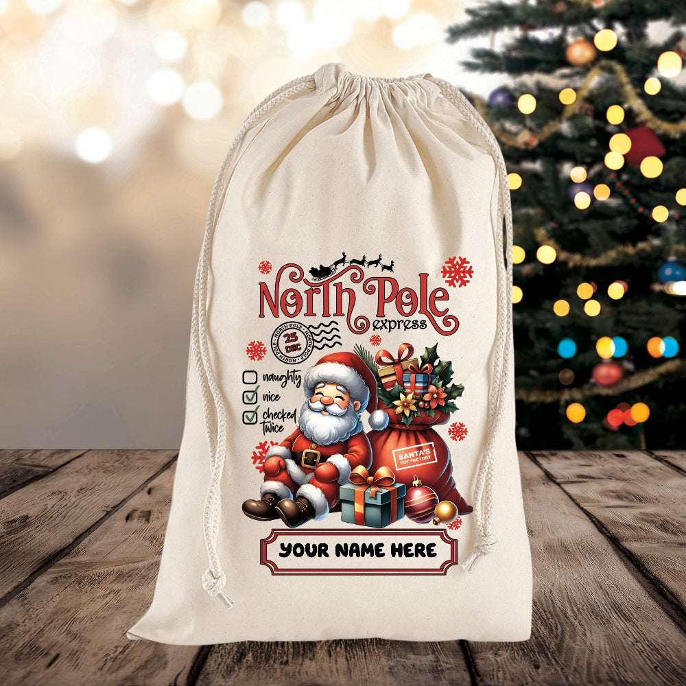 Decorative Christmas sack with Santa Claus design and 'North Pole Express' text on a wooden surface with a blurred Christmas tree in the background.